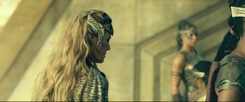 Movie still from “Wonder Woman 1984” (2020), directed by Patty Jenkins – A woman with long blonde hair wearing a costume; Close Up shot, Over the shoulder angle