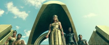 Movie still from “Wonder Woman 1984” (2020), directed by Patty Jenkins – A statue of a woman and a man in costume; Medium shot, Low angle