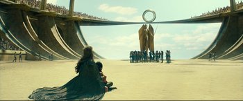 Movie still from “Wonder Woman 1984” (2020), directed by Patty Jenkins – A group of people gathered around a statue of elephants; Extreme Wide shot, Over the shoulder angle