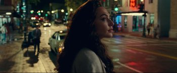 Movie still from “Wonder Woman 1984” (2020), directed by Patty Jenkins – A woman standing on the side of the street at night; Close Up shot, Over the shoulder angle