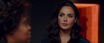 Movie still from “Wonder Woman 1984” (2020), directed by Patty Jenkins – A woman with long black wavy hair looking at the camera; Close Up shot, Over the shoulder angle