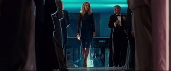 Movie still from “Wonder Woman 1984” (2020), directed by Patty Jenkins – A woman walking down a runway while holding a purse; Wide shot, Low angle