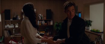 Movie still from “Wonder Woman 1984” (2020), directed by Patty Jenkins – A man and a woman holding hands in a living room; Medium shot, Over the shoulder angle