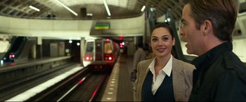 Movie still from “Wonder Woman 1984” (2020), directed by Patty Jenkins – A woman standing in front of a train platform; Medium shot, Over the shoulder angle