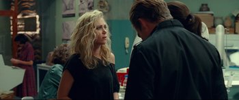 Movie still from “Wonder Woman 1984” (2020), directed by Patty Jenkins – A woman standing next to a man in front of a wall; Medium shot, Over the shoulder angle