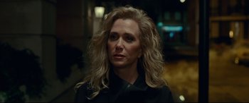 Movie still from “Wonder Woman 1984” (2020), directed by Patty Jenkins – A woman with long blonde hair wearing a black jacket; Close Up shot, Over the shoulder angle