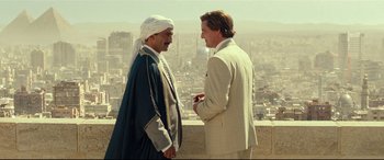 Movie still from “Wonder Woman 1984” (2020), directed by Patty Jenkins – Two men standing next to each other on a ledge; Medium shot, Over the shoulder angle