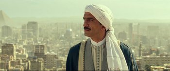 Movie still from “Wonder Woman 1984” (2020), directed by Patty Jenkins – A man with a turban on looking out over a city; Close Up shot, Low angle