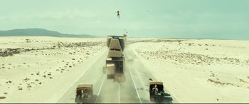 Movie still from “Wonder Woman 1984” (2020), directed by Patty Jenkins – A man flying through the air while standing on top of a truck; Extreme Wide shot, High angle