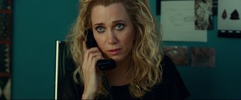 Movie still from “Wonder Woman 1984” (2020), directed by Patty Jenkins – A woman is talking on a phone and looking at the camera; Close Up shot, High angle