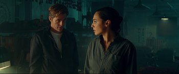 Movie still from “Wonder Woman 1984” (2020), directed by Patty Jenkins – A man and a woman standing next to each other in a room; Medium shot, Low angle