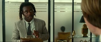 Movie still from “Wonder Woman 1984” (2020), directed by Patty Jenkins – A man sitting at a table in front of a window; Medium shot, Over the shoulder angle