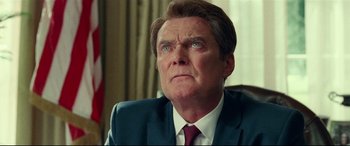 Movie still from “Wonder Woman 1984” (2020), directed by Patty Jenkins – A person wearing a suit and tie; Close Up shot, Low angle