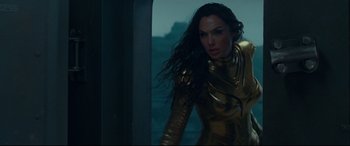 Movie still from “Wonder Woman 1984” (2020), directed by Patty Jenkins – A woman in a gold outfit; Medium shot, Low angle