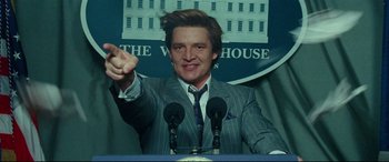 Movie still from “Wonder Woman 1984” (2020), directed by Patty Jenkins – A man wearing a suit and tie at a press conference; Close Up shot, Low angle