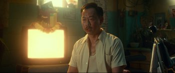 Movie still from “Wonder Woman 1984” (2020), directed by Patty Jenkins – A man in a white shirt is sitting in a dimly lit room; Close Up shot, Over the shoulder angle