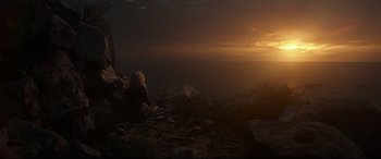 Movie still from “Wonder Woman 1984” (2020), directed by Patty Jenkins – A person sitting on top of a mountain looking at the sunset; Extreme Wide shot, High angle