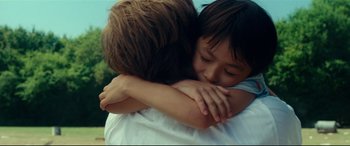Movie still from “Wonder Woman 1984” (2020), directed by Patty Jenkins – A young child is hugging an older child; Close Up shot, Over the shoulder angle