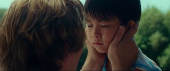 Movie still from “Wonder Woman 1984” (2020), directed by Patty Jenkins – A young boy holding his head in his hands; Close Up shot, Over the shoulder angle