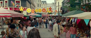 Movie still from “Wonder Woman 1984” (2020), directed by Patty Jenkins – A crowd of people walking down a street with umbrellas; Wide shot, High angle