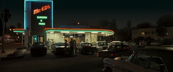 Movie still from “Zodiac” (2007), directed by David Fincher – A group of people standing in a parking lot at night; Extreme Wide shot, Low angle