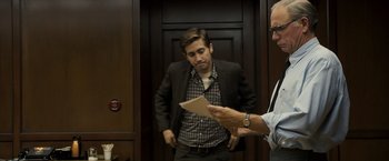 Movie still from “Zodiac” (2007), directed by David Fincher – A man standing next to another man in a elevator; Medium shot, Over the shoulder angle
