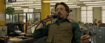 Movie still from “Zodiac” (2007), directed by David Fincher – A man sitting down talking on a phone; Medium shot, Low angle
