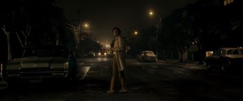 Movie still from “Zodiac” (2007), directed by David Fincher – A man standing on the side of a road at night; Wide shot, Low angle