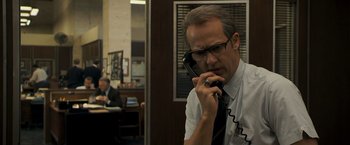 Movie still from “Zodiac” (2007), directed by David Fincher – A man talking on a phone in an office setting; Close Up shot, Low angle