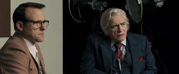 Movie still from “Zodiac” (2007), directed by David Fincher – An older man in a suit and red tie; Close Up shot, Over the shoulder angle