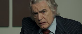 Movie still from “Zodiac” (2007), directed by David Fincher – An older man wearing a suit and tie; Close Up shot, Over the shoulder angle