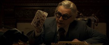 Movie still from “Zodiac” (2007), directed by David Fincher – An older man holding a piece of paper in his hand; Close Up shot, Low angle