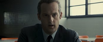 Movie still from “Zodiac” (2007), directed by David Fincher – A person wearing a suit and tie; Close Up shot, Low angle