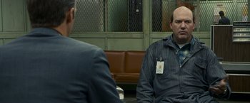 Movie still from “Zodiac” (2007), directed by David Fincher – Two men sitting in front of each other in front of a bench; Medium shot, Over the shoulder angle