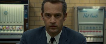Movie still from “Zodiac” (2007), directed by David Fincher – A person wearing a suit and tie; Close Up shot, Low angle