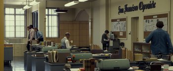 Movie still from “Zodiac” (2007), directed by David Fincher – Two men working in a cluttered office space; Wide shot, Low angle