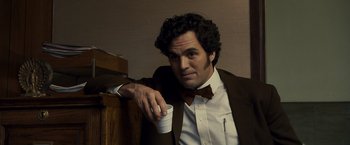 Movie still from “Zodiac” (2007), directed by David Fincher – A man in a suit and tie holding a cup; Close Up shot, Low angle