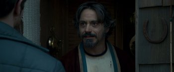 Movie still from “Zodiac” (2007), directed by David Fincher – A person with long hair and a beard; Close Up shot, Over the shoulder angle