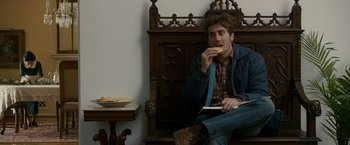 Movie still from “Zodiac” (2007), directed by David Fincher – A man sitting on top of a wooden bench eating a sandwich; Medium shot, Over the shoulder angle