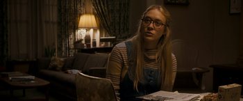 Movie still from “Zodiac” (2007), directed by David Fincher – A woman sitting at a table in a living room; Medium shot, Over the shoulder angle