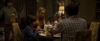 Movie still from “Zodiac” (2007), directed by David Fincher – A group of people sitting around a table eating food; Medium shot, High angle