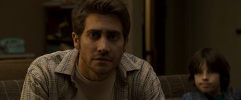Movie still from “Zodiac” (2007), directed by David Fincher – A person wearing a plaid shirt; Close Up shot, Over the shoulder angle