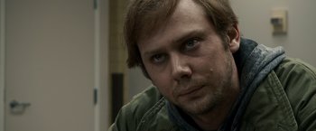 Movie still from “Zodiac” (2007), directed by David Fincher – A person wearing a green jacket; Close Up shot, Over the shoulder angle