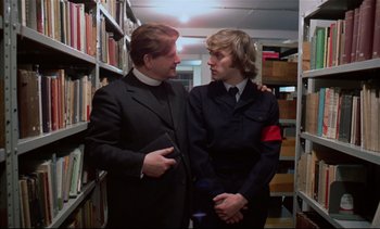 Movie still from “A Clockwork Orange” (1971), directed by Stanley Kubrick – Two men in suits standing next to each other in a library; Medium shot, Low angle