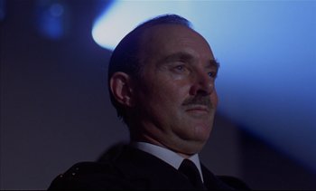 Movie still from “A Clockwork Orange” (1971), directed by Stanley Kubrick – A person wearing a suit and tie; Close Up shot, Low angle