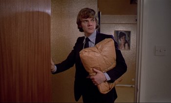 Movie still from “A Clockwork Orange” (1971), directed by Stanley Kubrick – A young man holding a pillow in a room; Medium shot, Low angle