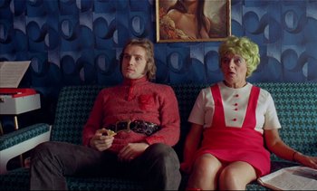 Movie still from “A Clockwork Orange” (1971), directed by Stanley Kubrick – A man and a woman sitting on a couch; Medium shot, High angle