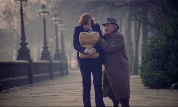Movie still from “A Clockwork Orange” (1971), directed by Stanley Kubrick – An older man and a younger woman walking down a sidewalk; Wide shot, High angle