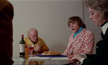 Movie still from “A Clockwork Orange” (1971), directed by Stanley Kubrick – Two men and a woman sitting at a dinner table; Medium shot, Over the shoulder angle