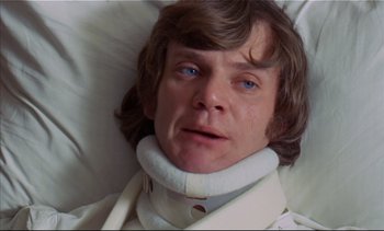 Movie still from “A Clockwork Orange” (1971), directed by Stanley Kubrick – A man wearing a neck brace laying in a bed; Close Up shot, Low angle